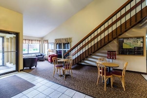Un hall de hotel con una escalera, una zona de estar y un mapa en la pared.