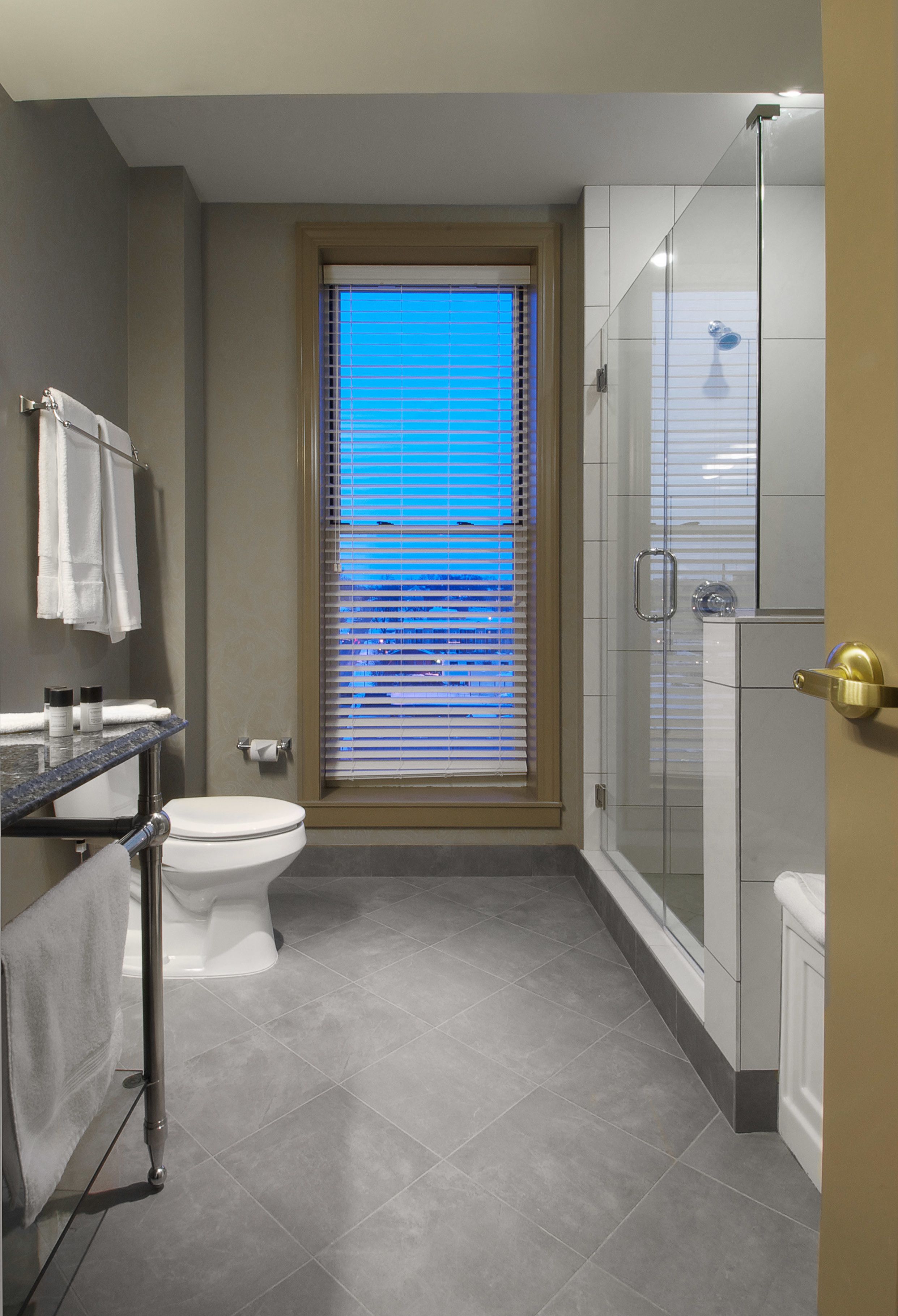 A modern bathroom with a toilet, sink, and shower.