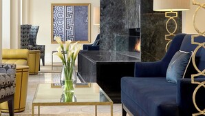 A modern living room with a sofa, armchairs, a coffee table, and a fireplace. - Hotel Blackhawk, Autograph Collection (Davenport)