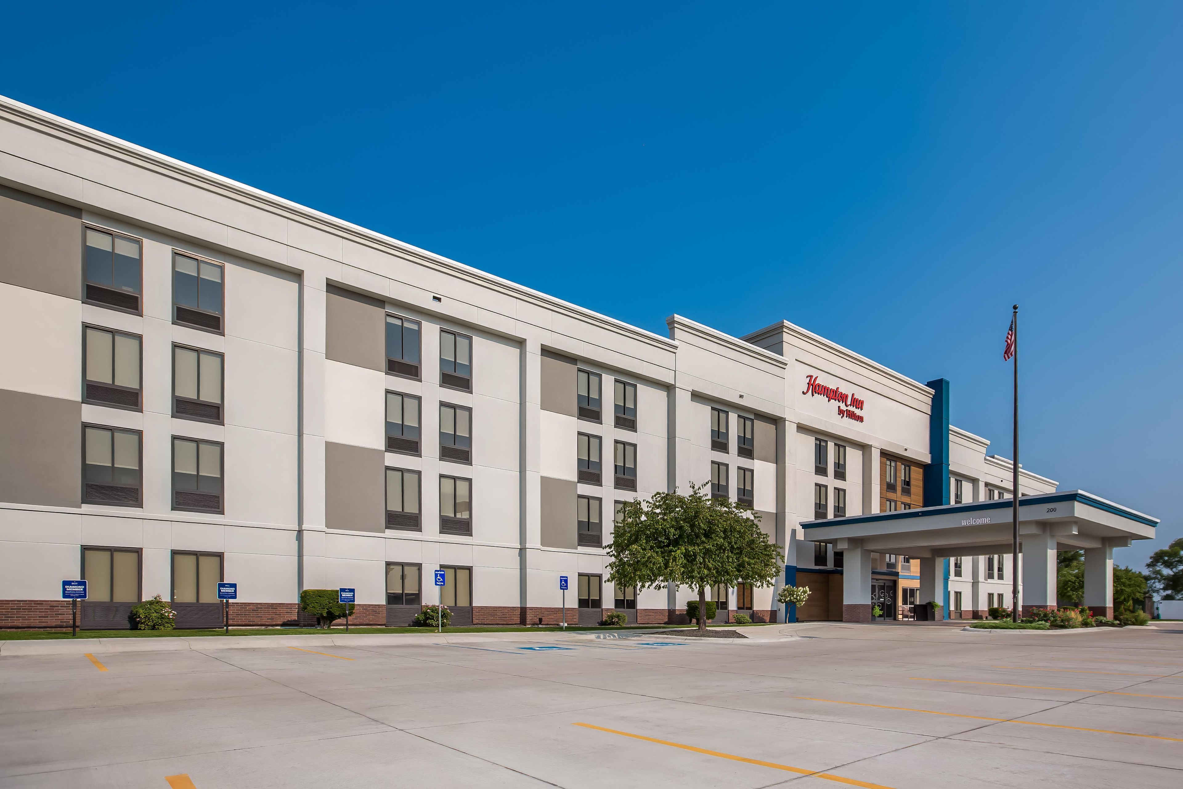A modern hotel building with a flat facade, multiple windows, and a welcoming entrance.