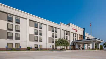 A modern hotel building with a flat facade, multiple windows, and a welcoming entrance.