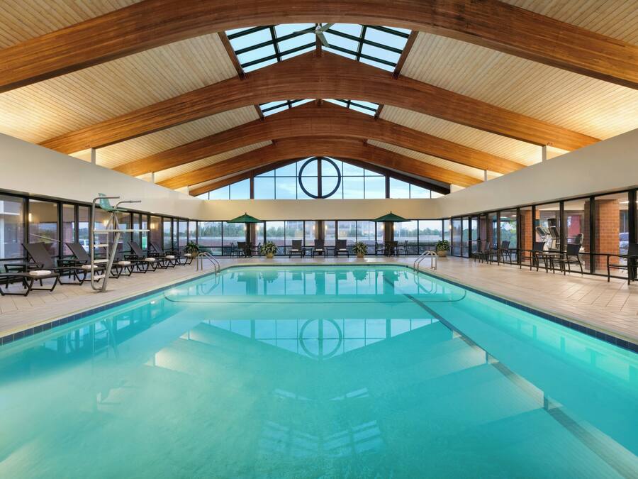 Una piscina interior con techo alto y ventanas amplias.