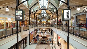 A multi-level shopping mall with a central atrium, upper and lower floors, and a variety of retail stores. - Holiday Inn Washington-Dulles International Airport by IHG (Sterling)