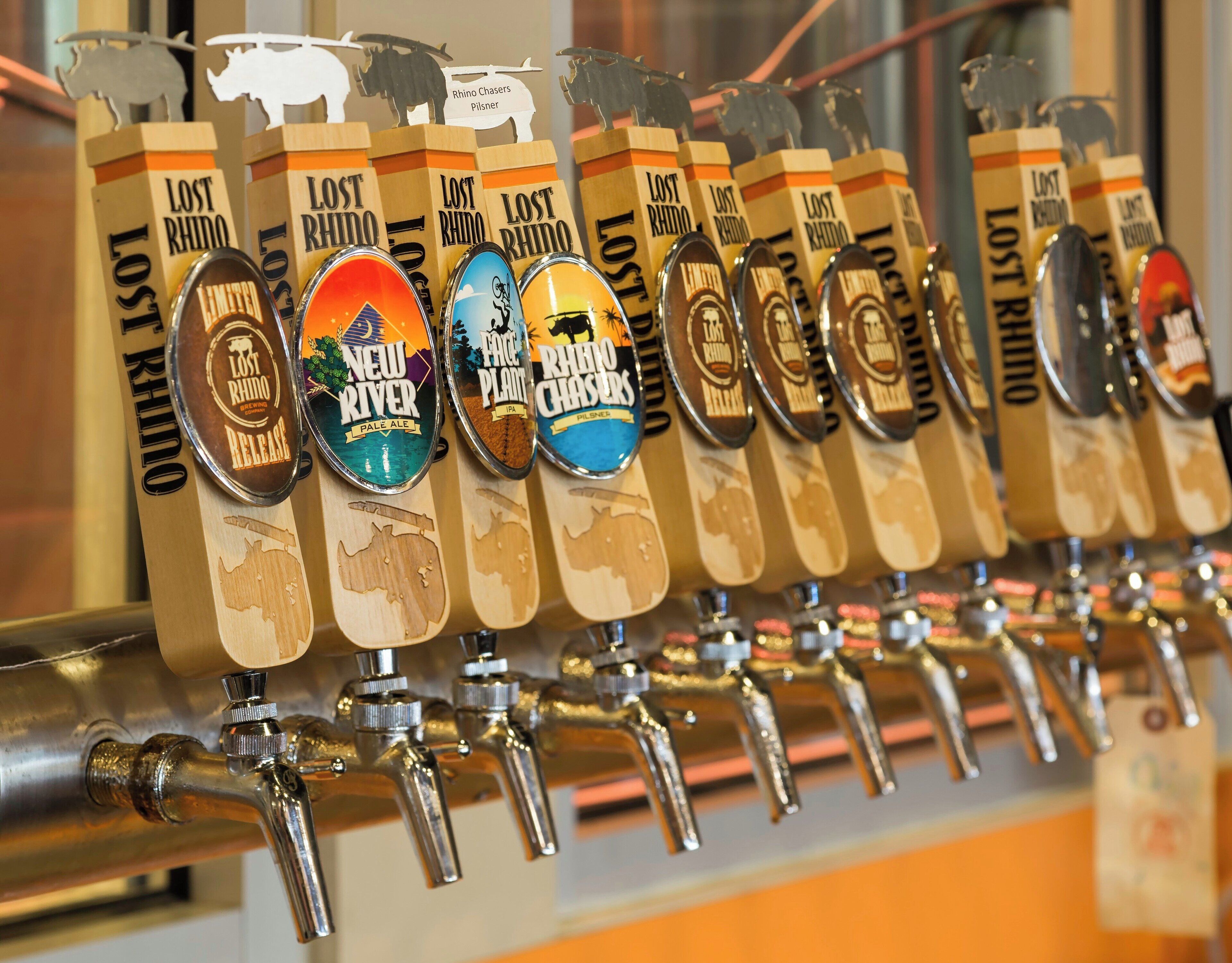 Een rij bierkraan tappen, elk voorzien van een andere biernaam en -type.