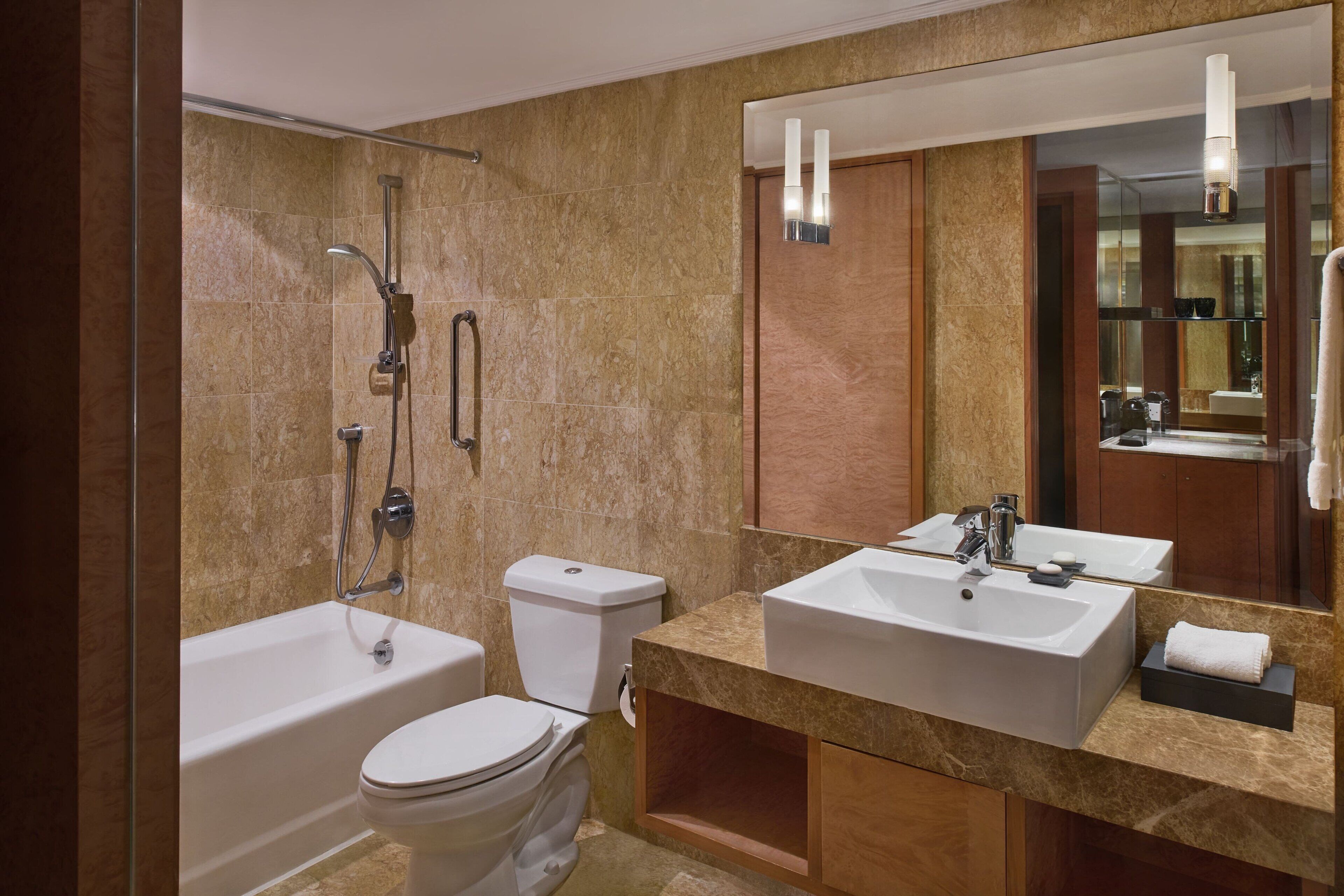 Un baño moderno con bañera, inodoro y dos lavamanos.