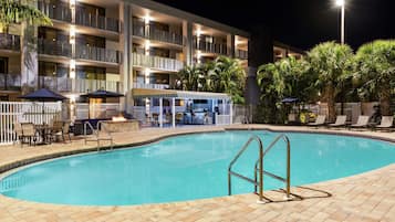 Un hotel con piscina, zona de estar al aire libre y bar.