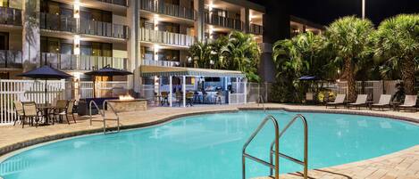 Un hotel con piscina, zona de estar al aire libre y bar.