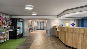 Eine Hotte lobby mit einer Rezeption, einer Getränkeauswahl inklusive Kühlschrank und einer Mikrowelle.