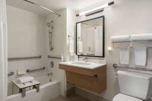 Un baño moderno con bañera, lavamanos e inodoro.