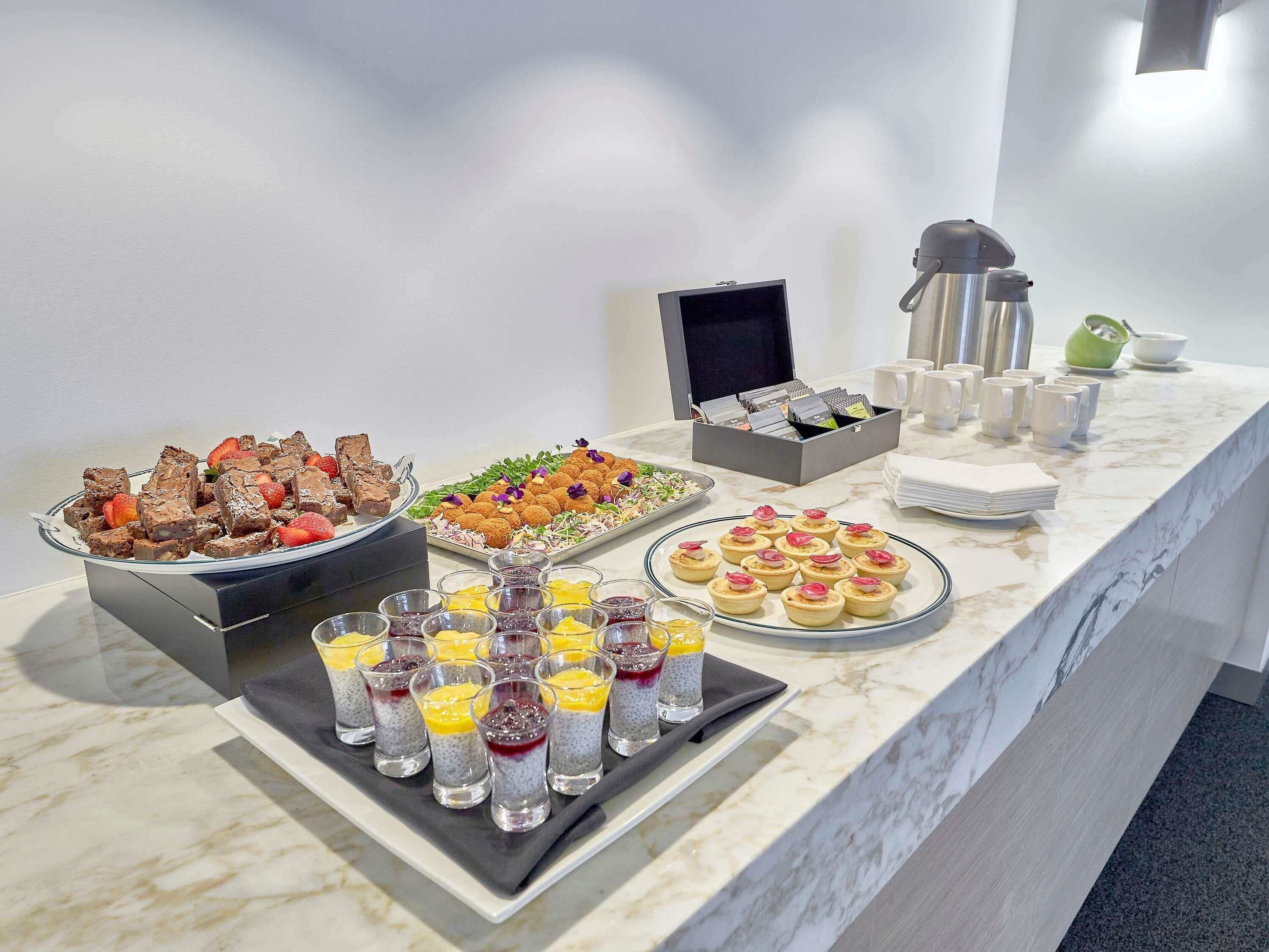 A buffet with various desserts and beverages.