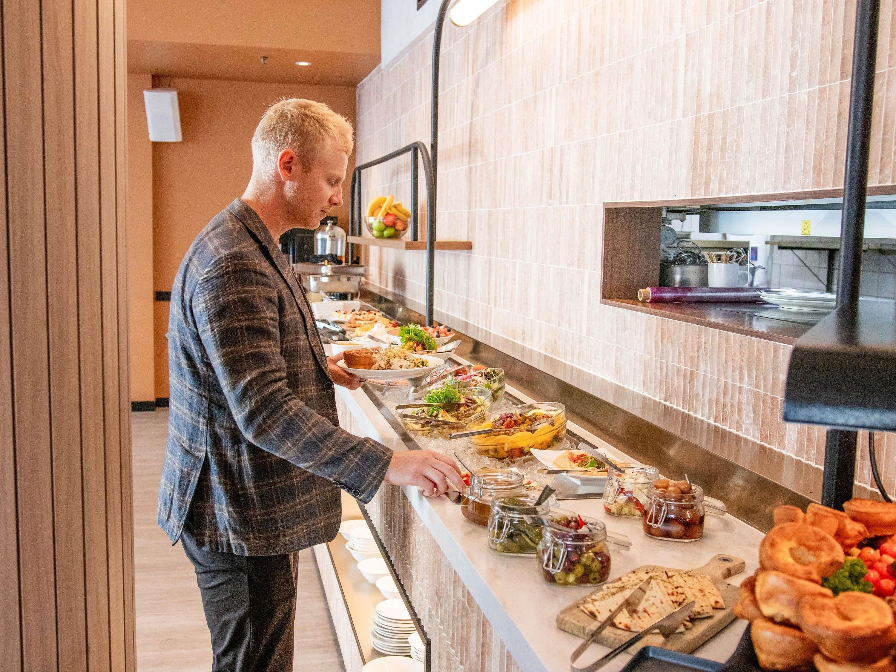 A buffet setup with various food items and condiments.