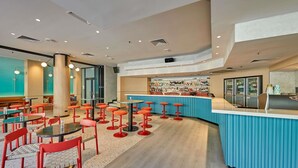 A modern bar area with a curved counter, multiple stools, and a variety of bottles and glasses on display. - ibis Perth (Perth)