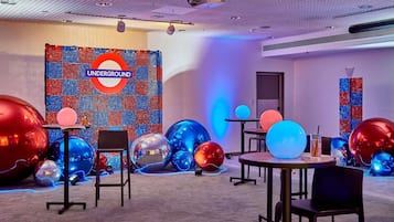 Una habitación con un gran letrero 'Underground', múltiples decoraciones esféricas y suelo alfombrado.