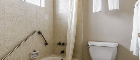 A bathroom with a bathtub, shower, and toilet.