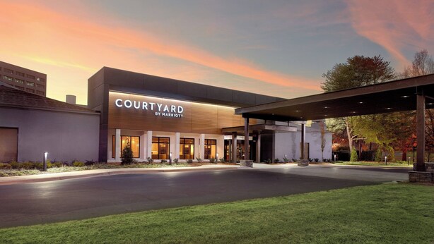 A Courtyard by Marriott hotel with a modern facade, large entrance, and covered outdoor area.