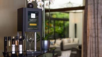 A wine rack with bottles and a glass, a potted plant, and a screen displaying text.