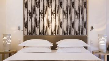 A hotel room with a large bed, two bedside tables, a wall-mounted artwork, and a modern lamp.