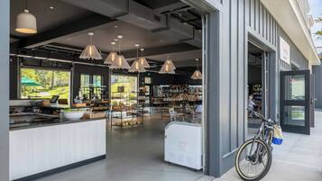 A cafe with a counter, hanging pendant lights, and a bicycle parked outside.