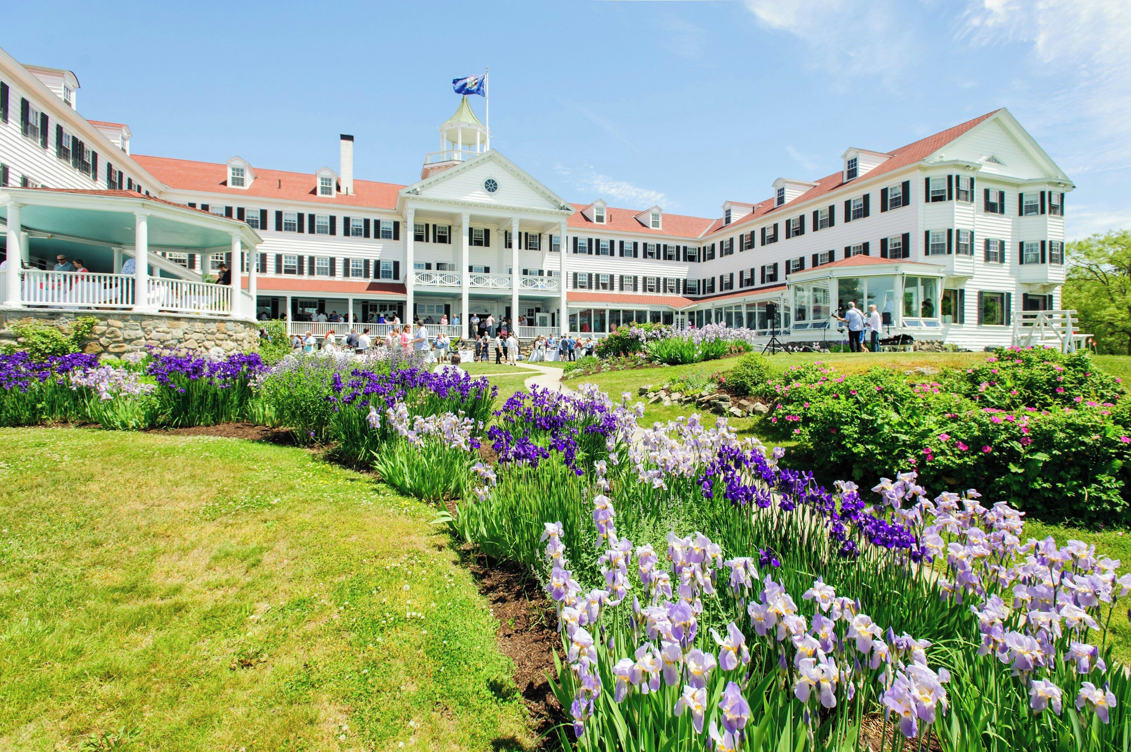A large, multi-story building with a central white structure and a flag on top.