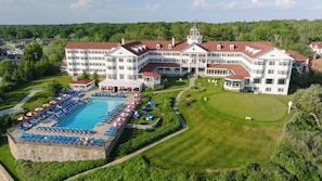 A large hotel with a swimming pool, multiple lounge areas, and a golf course.