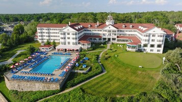Un hotel grande con piscina, varias áreas de descanso y un campo de golf.