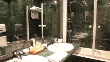 Ein modernes Badezimmer mit zwei Waschbecken, einer Glasdusche und einem großen Spiegel.