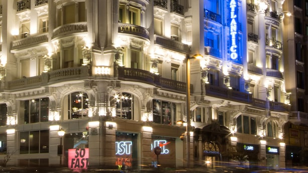 A grand hotel with multiple floors, ornate architectural details, and illuminated signage.