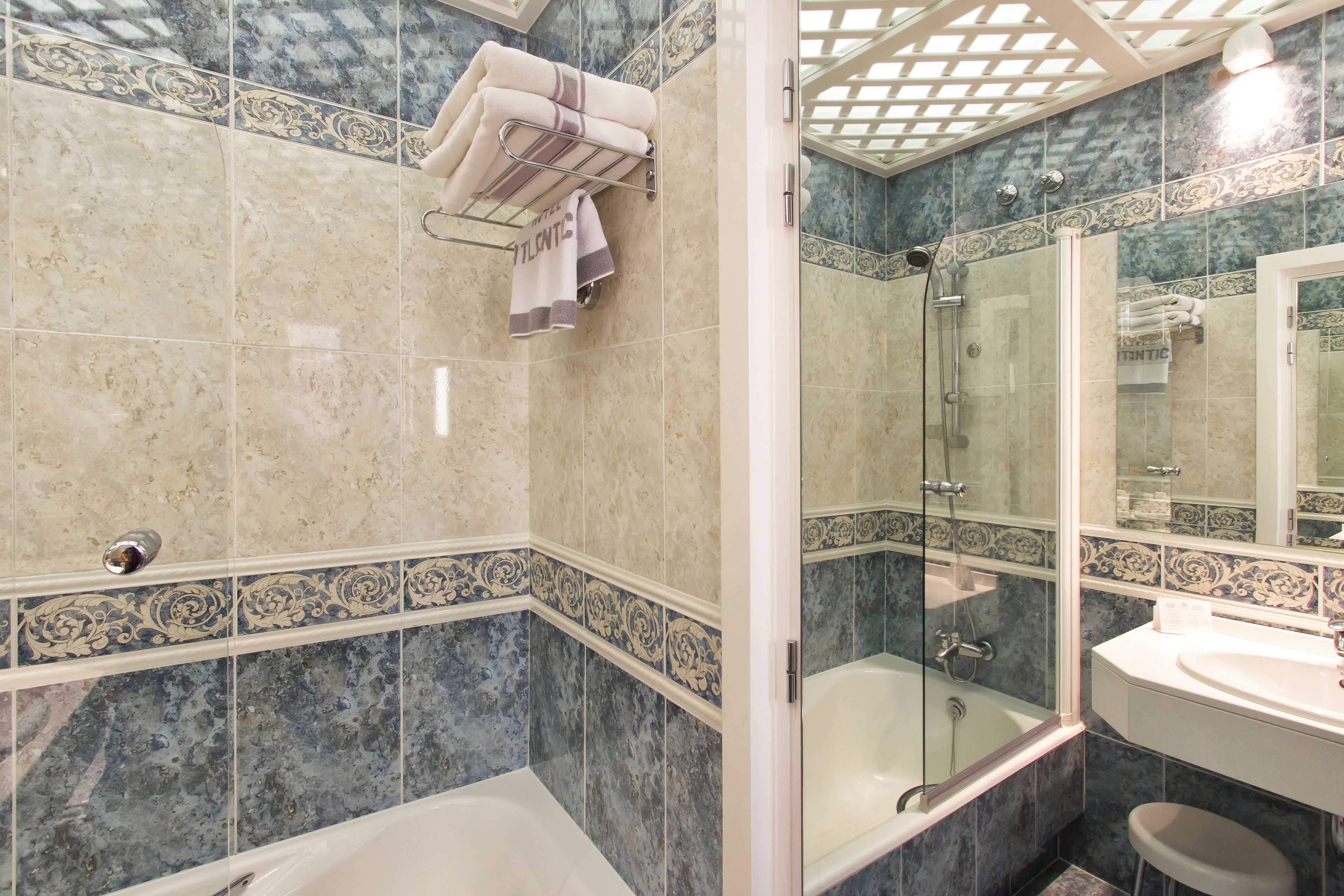 A bathroom with a bathtub, shower, and sink.