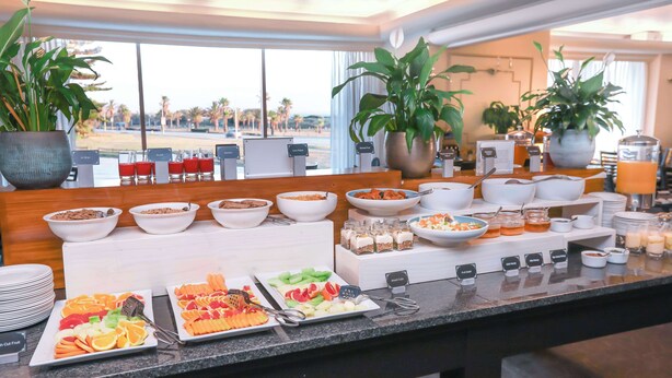 Un buffet proposant une variété de plats, notamment des fruits, des céréales et des boissons.