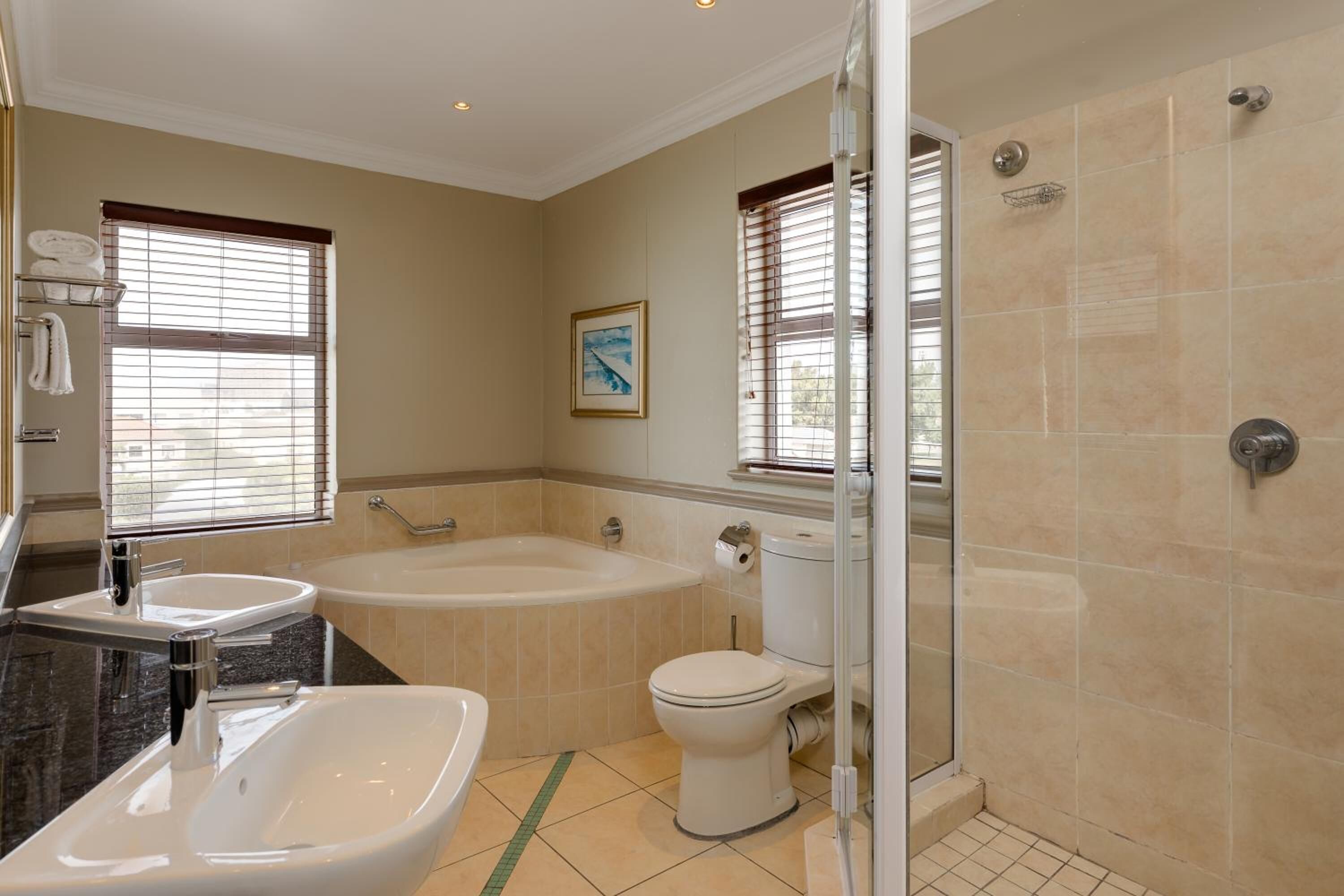 A bathroom with a bathtub, a toilet, and a shower area.