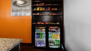 Máquina expendedora y refrigerador llenos de aperitivos y bebidas en el vestíbulo de un hotel.