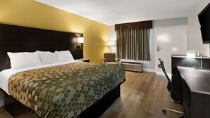 Una habitación de hotel con una cama grande, un escritorio, una silla y un televisor.