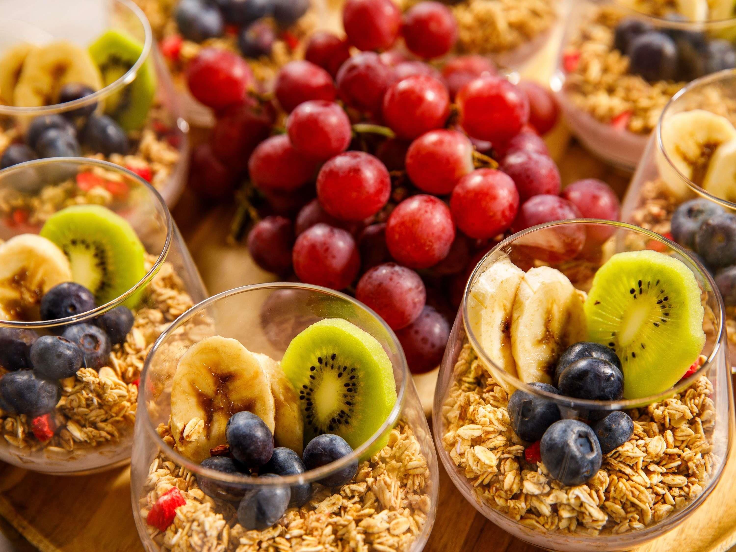 A variety of fruit bowls with granola and berries.