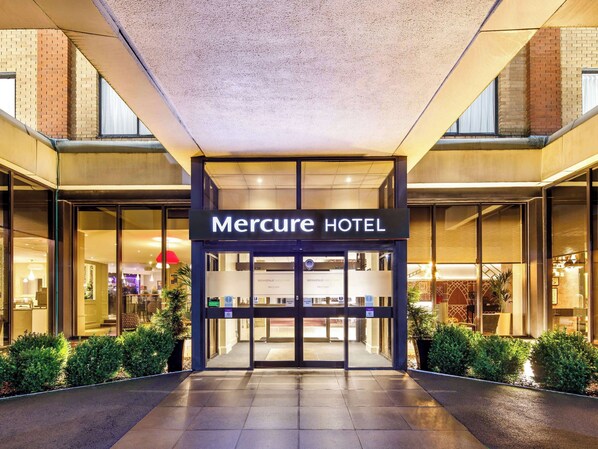 Welcome to Mercure Hotel, featuring a modern entrance and a clean, welcoming exterior with a glass facade.
