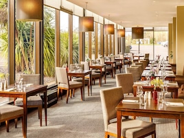 Un restaurante con mesas largas, sillas e iluminación colgante.