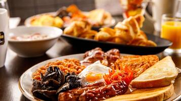 A breakfast plate with sausages, eggs, mushrooms, and toast.