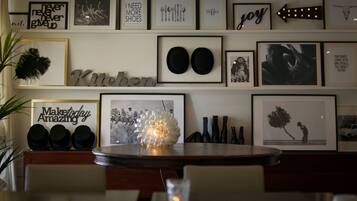 A wall with various framed pictures and text, including 'Kitchen' and 'Maketoday Amazing'.