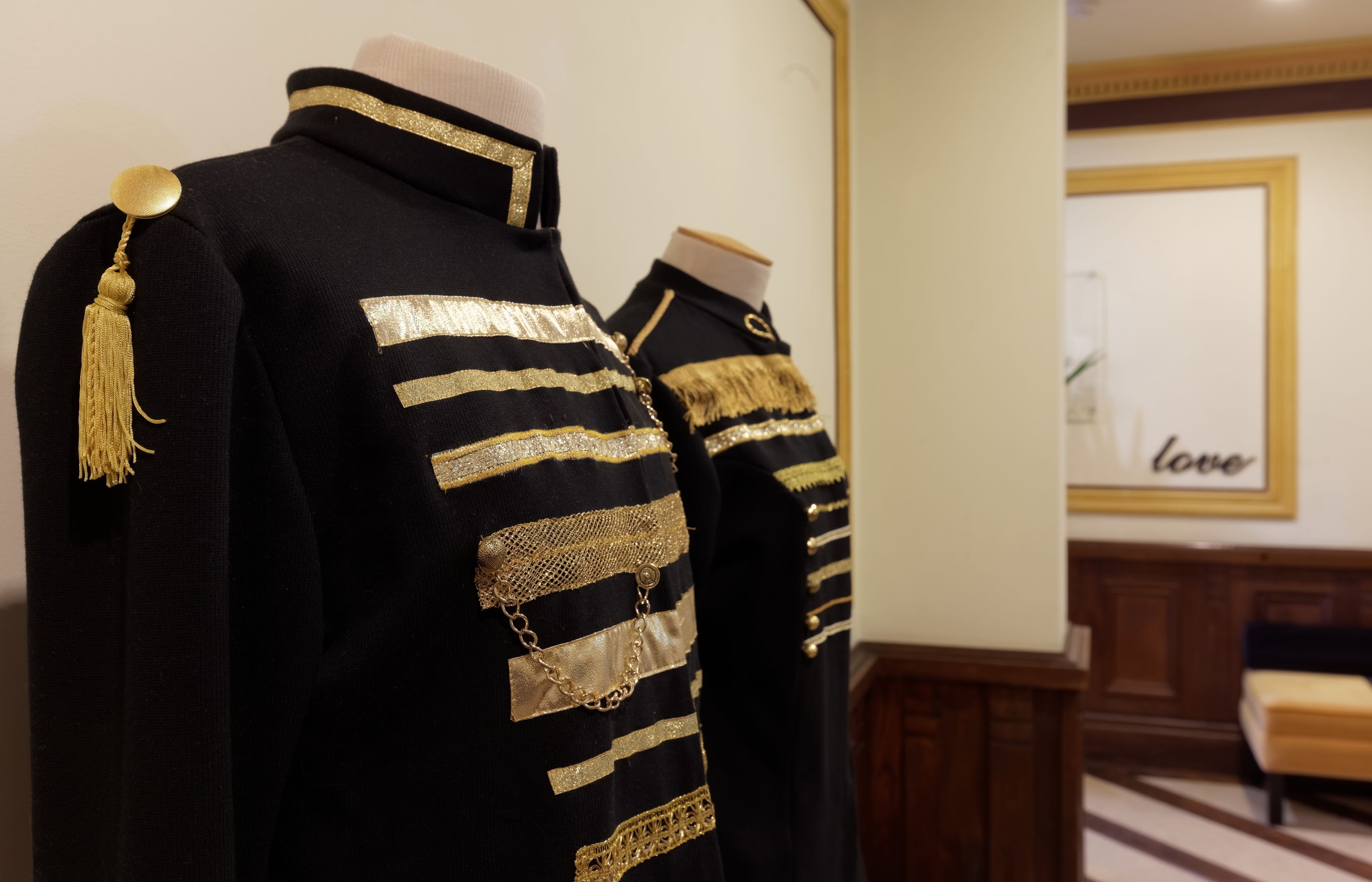 Un mannequin vêtu d’un uniforme noir et doré agrémenté d’éléments décoratifs.