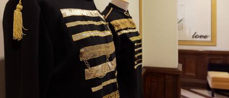 Un mannequin vêtu d’un uniforme noir et doré agrémenté d’éléments décoratifs.