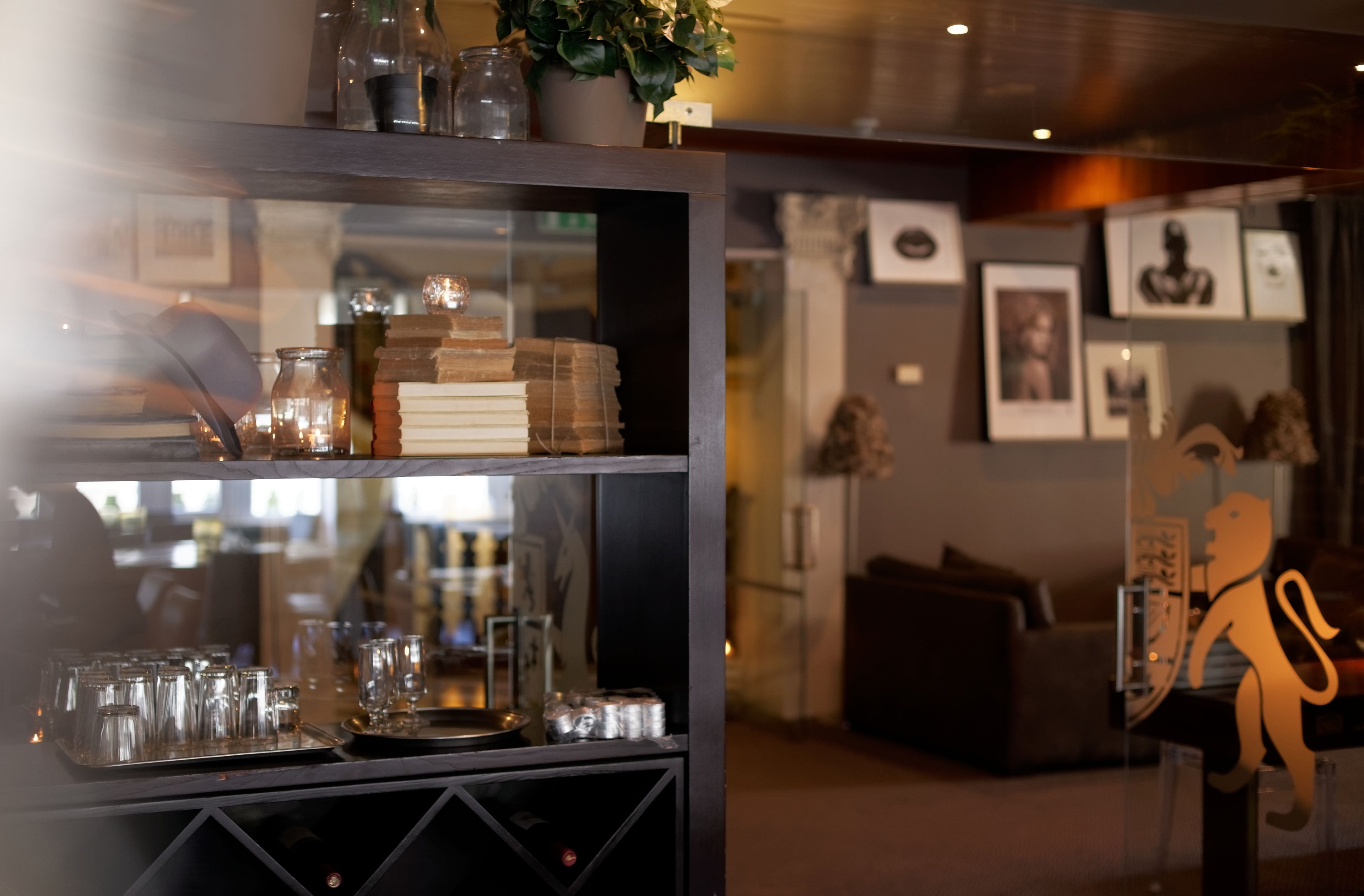 Een glazen vitrine met diverse artikelen, waaronder potten, boeken en glazen.