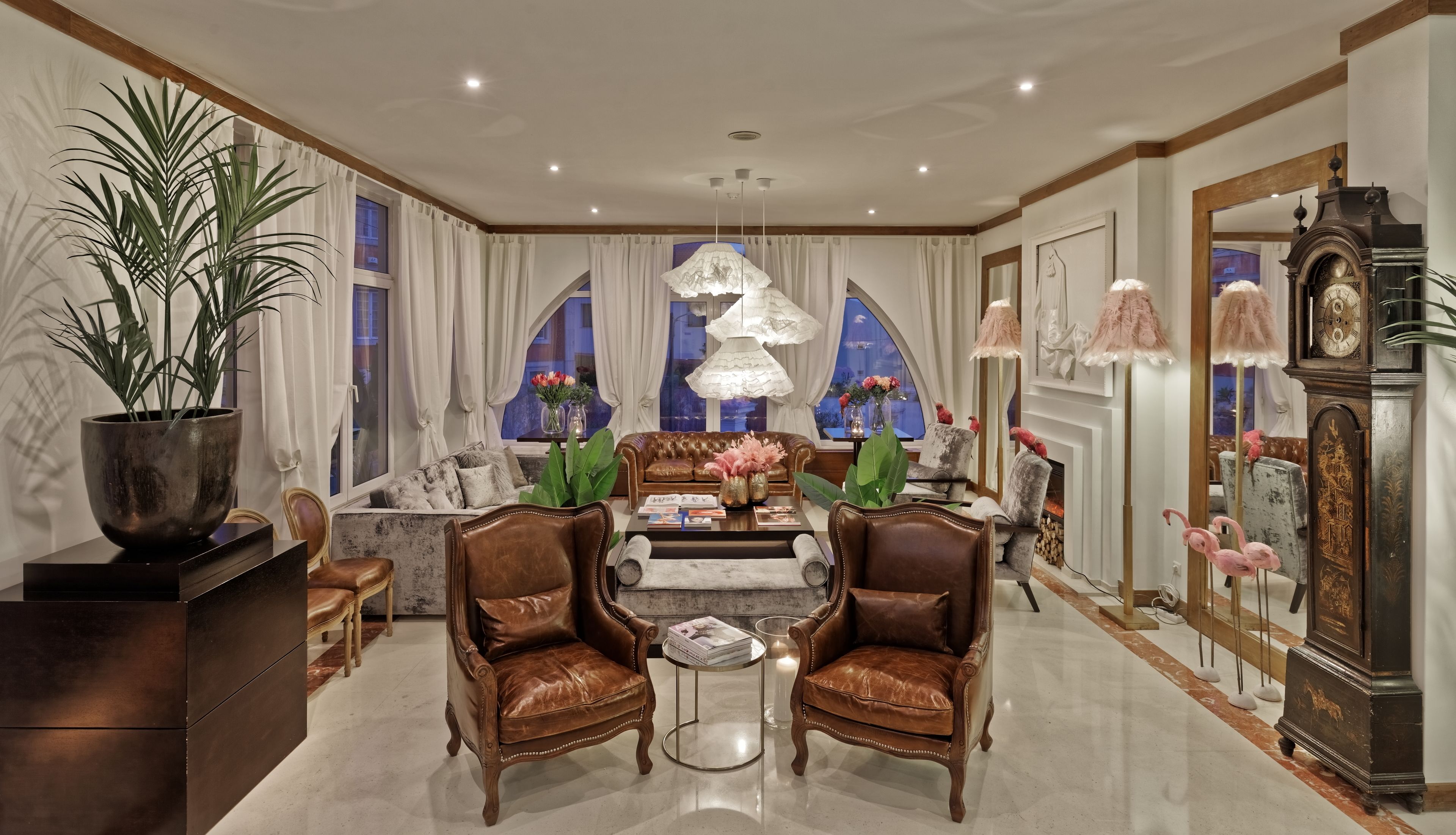 A luxurious living room with a leather sofa, a coffee table, and a fireplace.