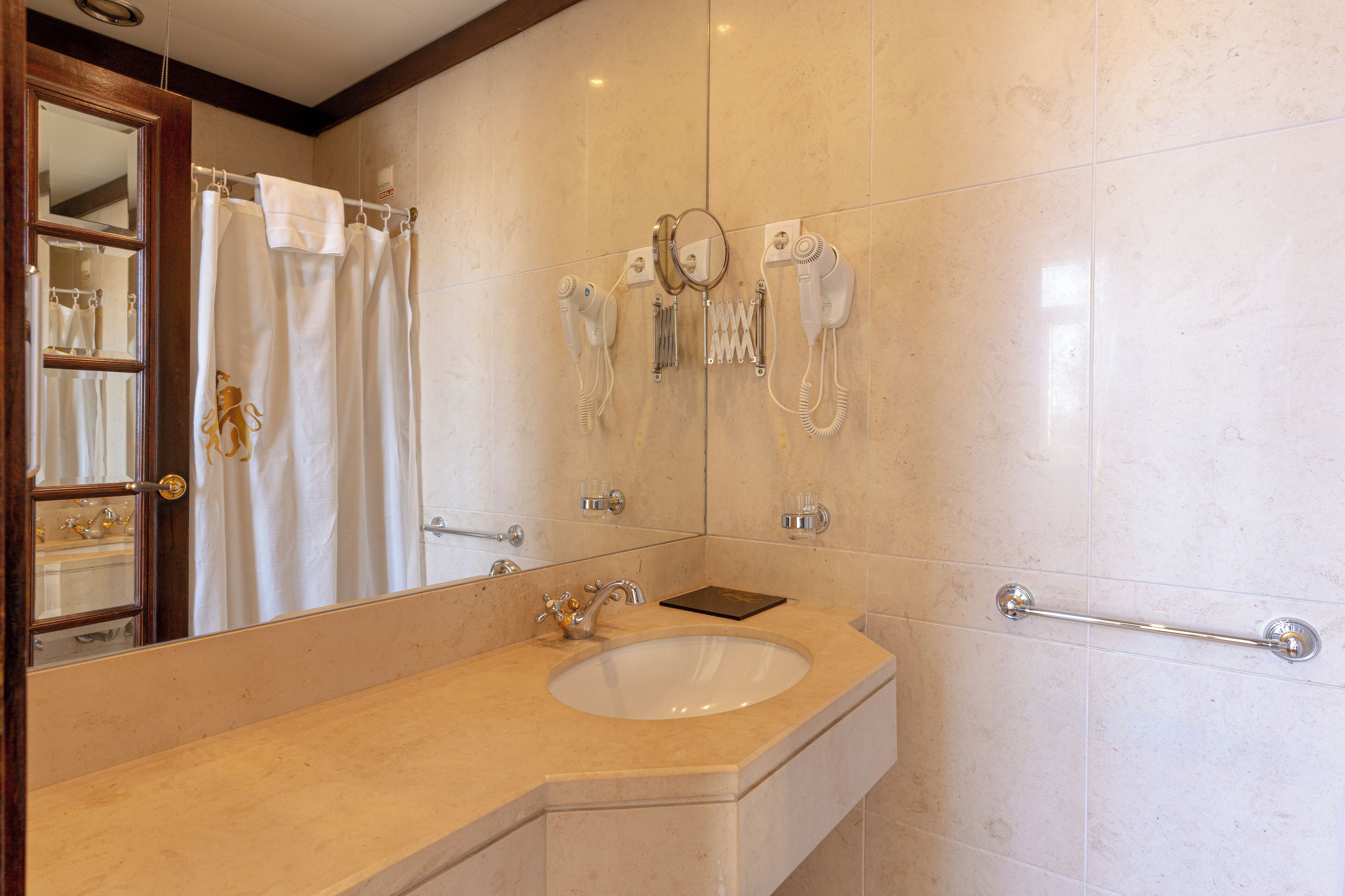 A bathroom with a sink, mirror, towel rack, and hairdryer.