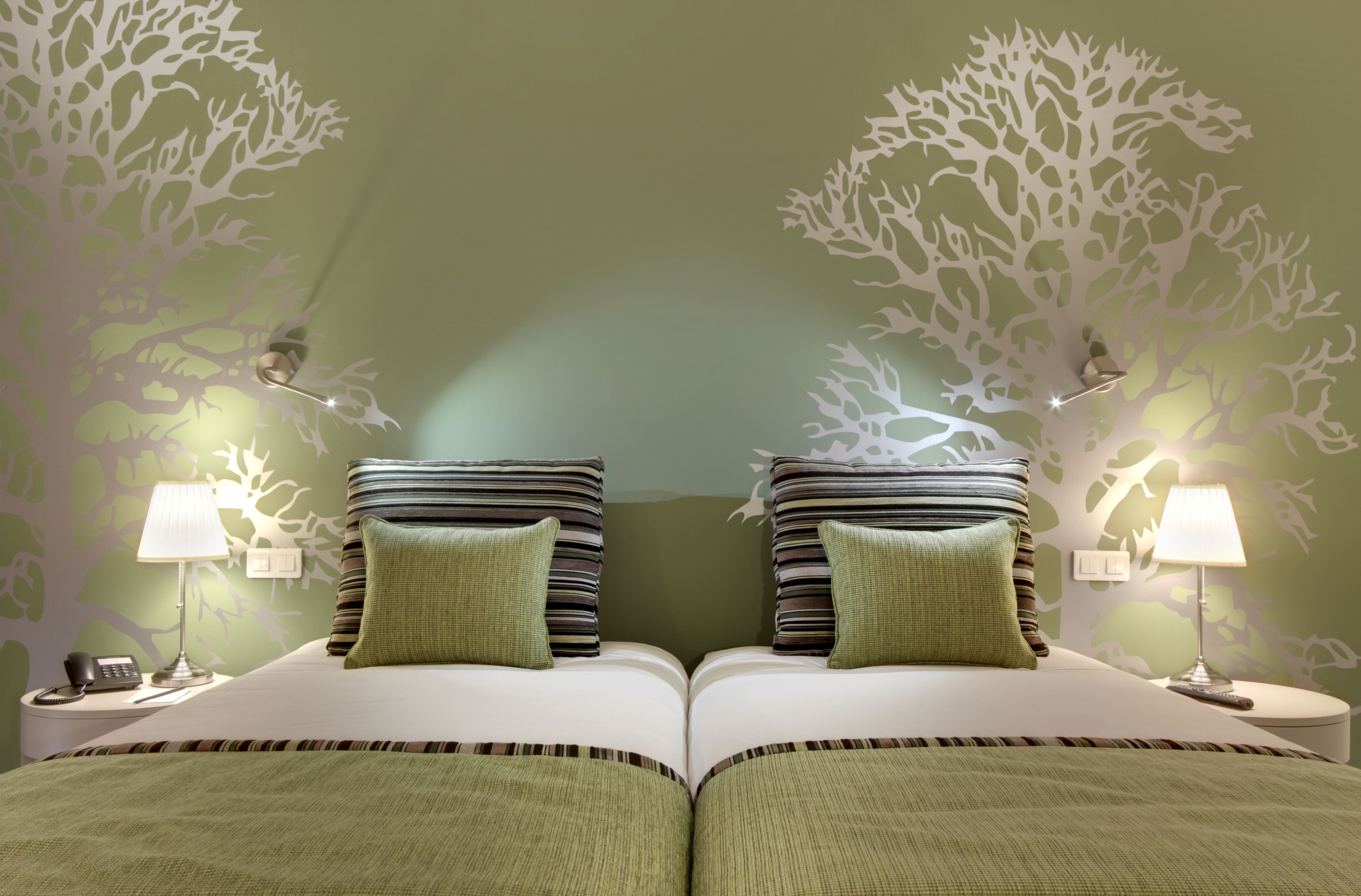 A double bed with two nightstands, each with a lamp and a phone.