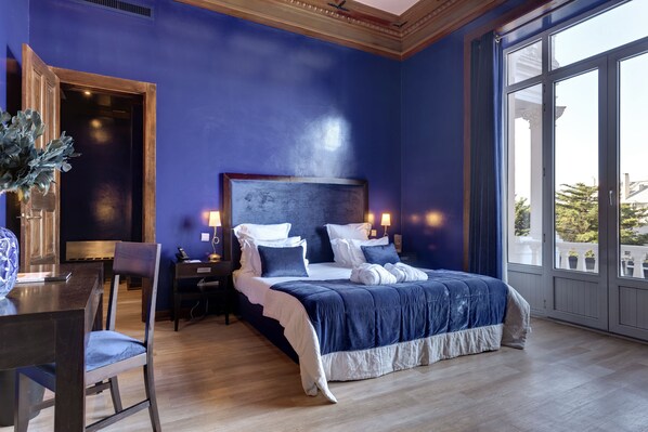 Un dormitorio con una cama grande, una mesita de noche, un escritorio y una silla.