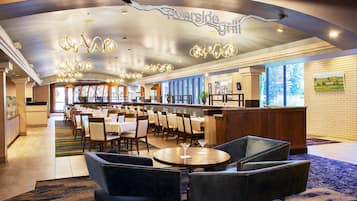 A restaurant with a bar area, multiple tables, and chairs.