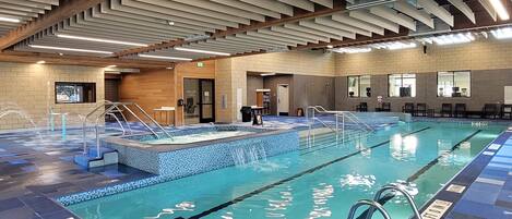 An indoor swimming pool with clear lane markings, a changing room, and a reception area.