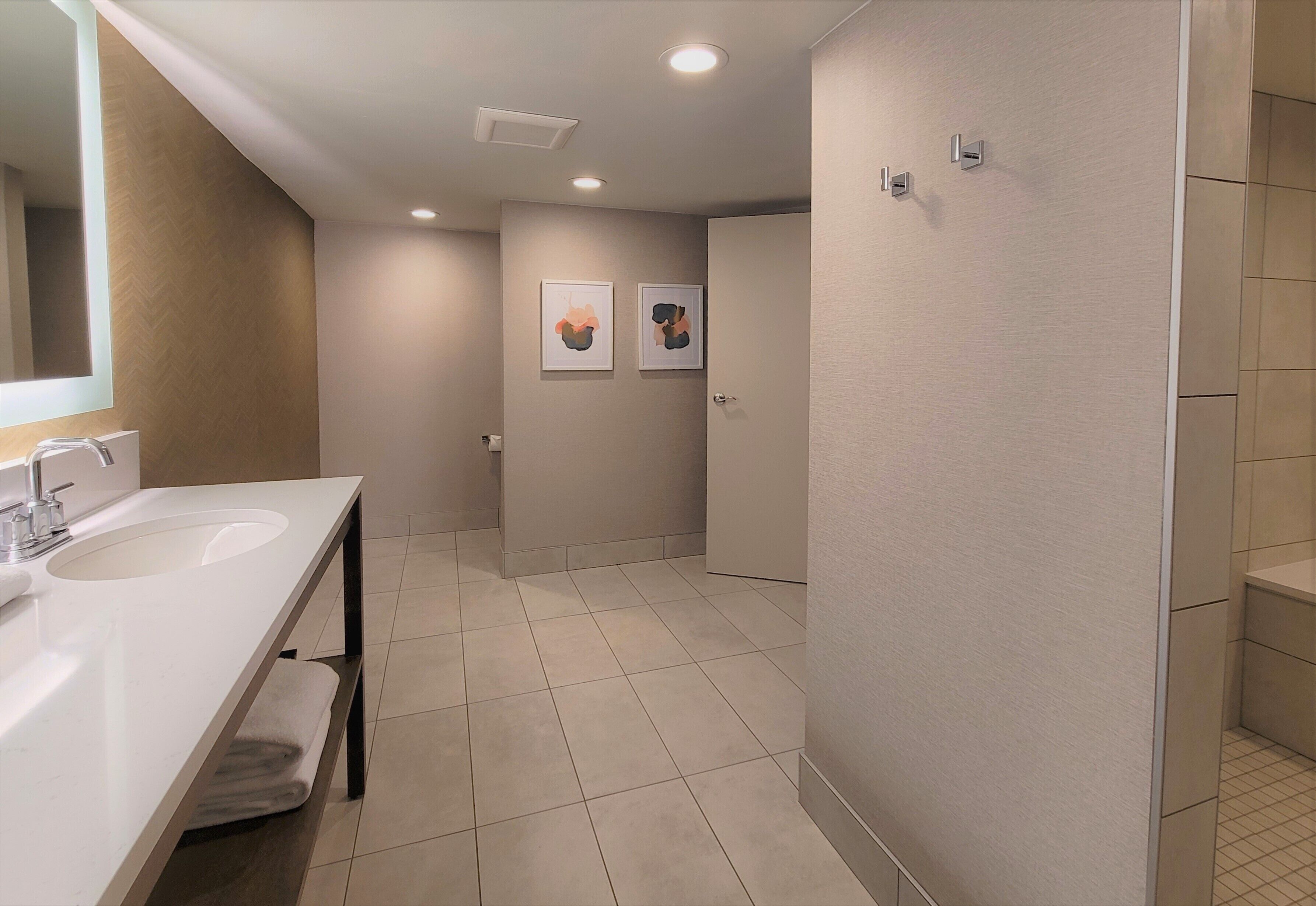 Een moderne badkamer met twee wastafels, een spiegel en een douche.