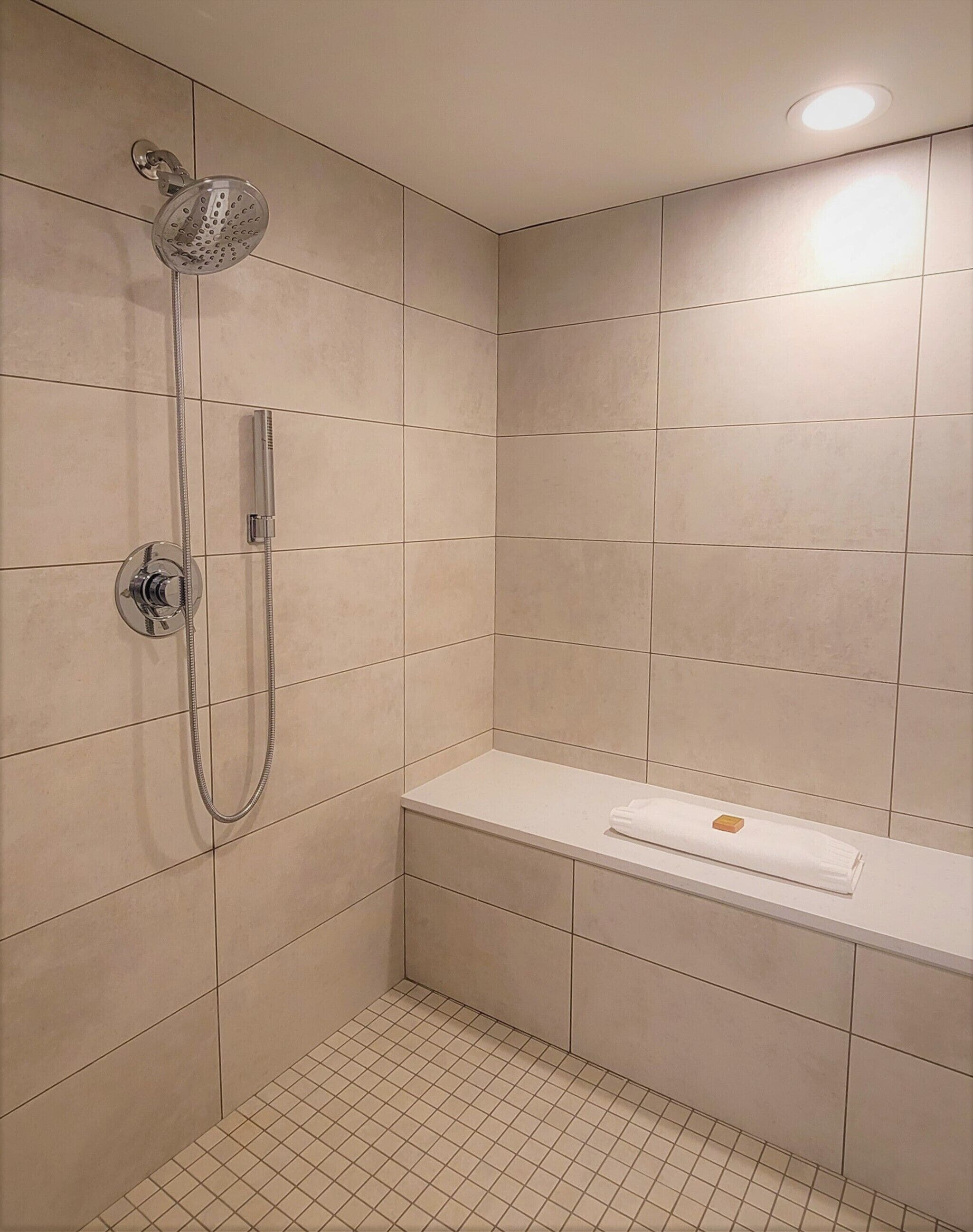 A modern bathroom with a shower, a toilet, and a sink.
