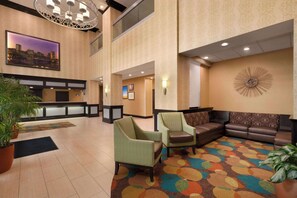 Relax in the hotel's spacious lobby, featuring a seating area with a sofa and armchairs.