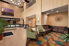 Relax in the hotel's spacious lobby, featuring a seating area with a sofa and armchairs.